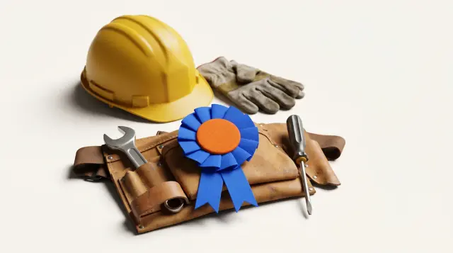 Founder's rosette in brand blue and tangerine resting on a worn leather tool belt with safety helmet and gloves